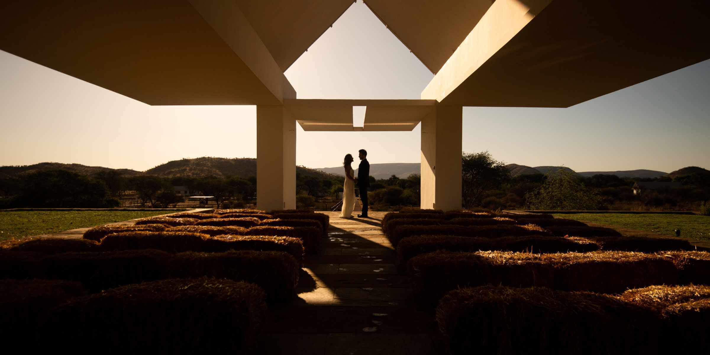 A couple on their wedding day silhouetted against the skyline in the Sandwerf chappel.