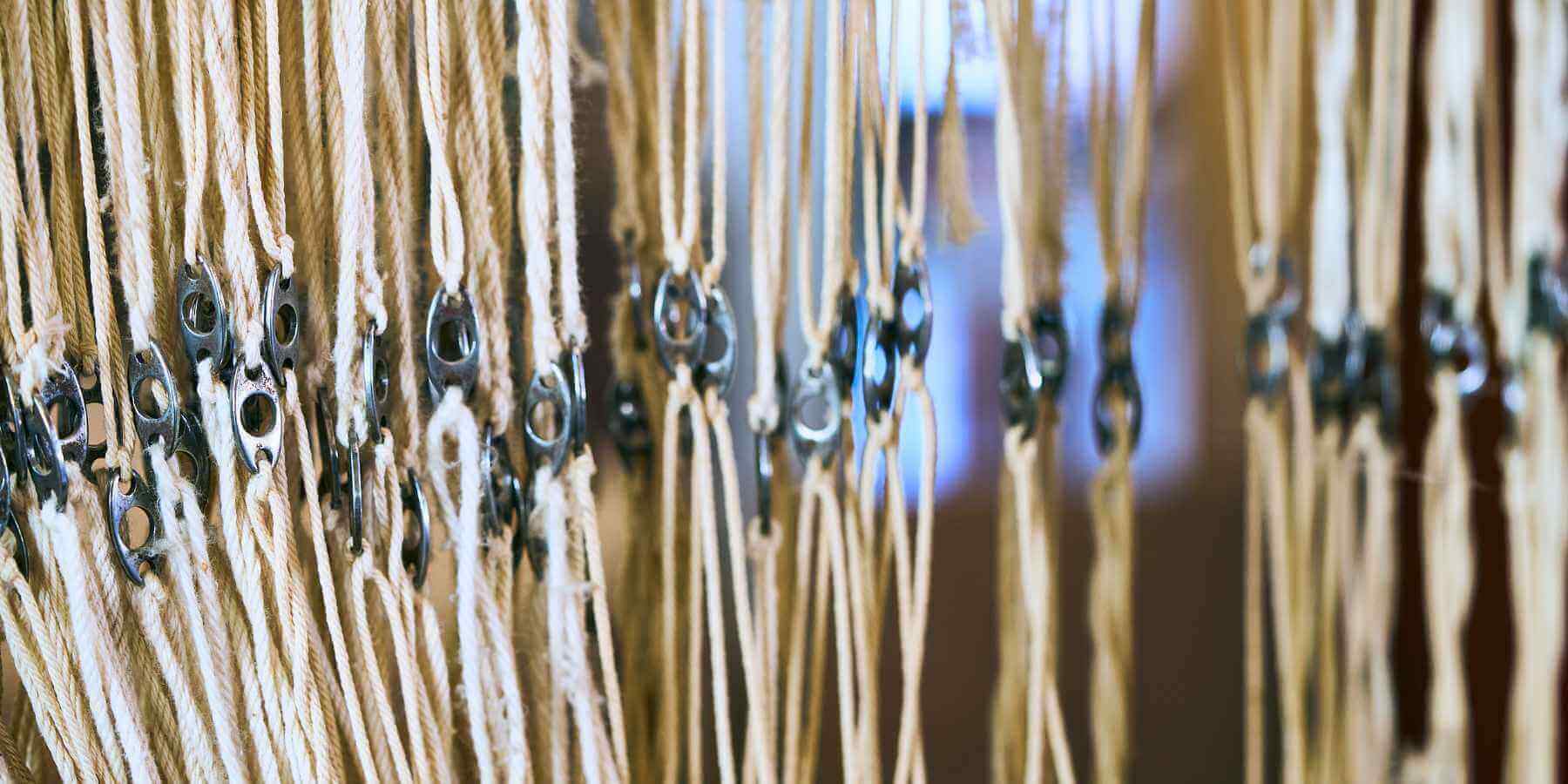 The loom's strings on one of the original looms in the Sandwerf Weavery.
